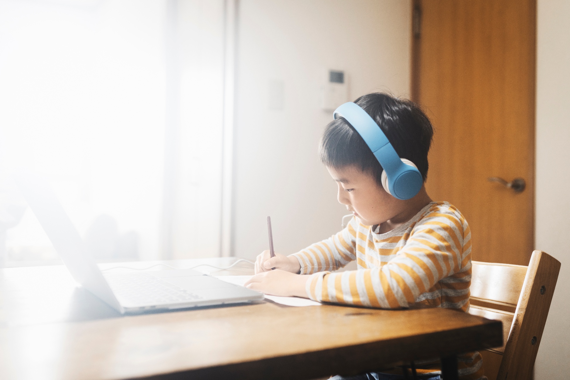 Student working at a table and computer